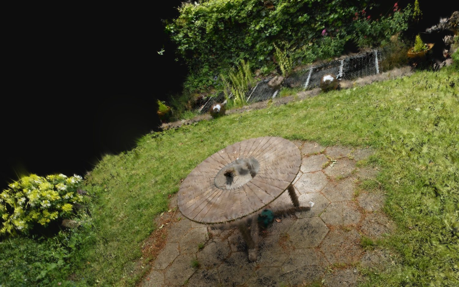 SplatStage after removing a cylinder-selected object from the Garden scene. The surrounding garden remains visible, while the removed region leaves a soft grey scar because the hidden background was never observed.